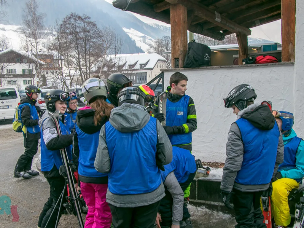 Jugendliche stehen unter einem Vordach an der Piste.